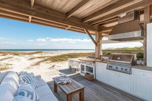 A beachside outdoor kitchen with seating, offering a scenic view of the ocean and dunes photo