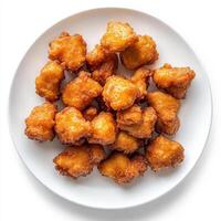 A plate of golden, crispy fried nuggets, ready to be enjoyed as a snack or appetizer photo