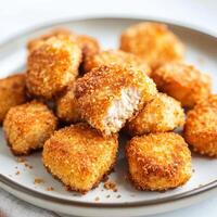 A plate of golden-brown, crispy chicken nuggets, ready to be enjoyed as a tasty snack photo