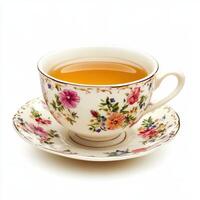 A delicate floral teacup filled with golden tea on a matching saucer. photo