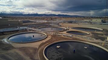 Aerial view of water treatment facility with circular tanks and pipelines. photo