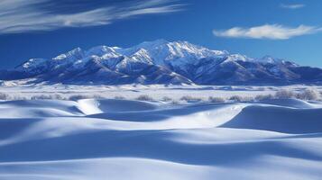 A serene winter landscape featuring snow-covered mountains and rolling snowdrifts photo