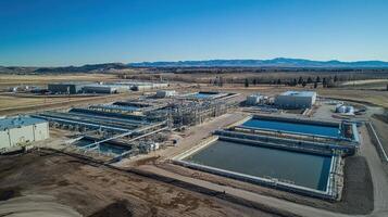 Aerial view of an industrial facility with large water treatment tanks and processing structures photo