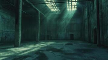 A dimly lit industrial space with beams of light filtering through broken windows photo