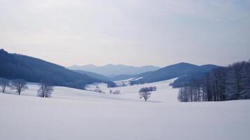 A serene winter landscape with rolling hills, snow-covered fields, and distant mountains photo