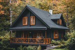 A cozy black wooden house surrounded by autumn foliage. photo