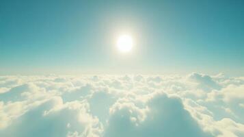 A bright sun shining over a sea of fluffy clouds in a clear blue sky. photo
