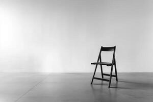 A solitary black folding chair positioned in a minimalist, empty interior space. photo