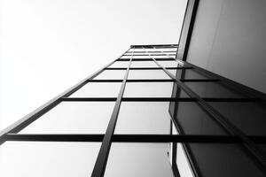 A low-angle view of a modern glass building, emphasizing its sleek architectural design. photo