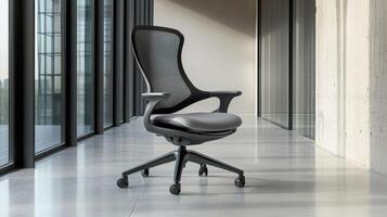 A modern ergonomic office chair in a sleek, minimalistic workspace with large windows. photo