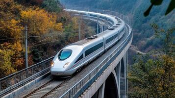 A high-speed train navigating a curved track through a scenic landscape with autumn foliage. photo