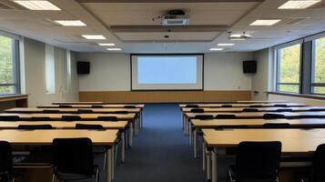 A spacious conference room with rows of tables and chairs, ready for a presentation. photo