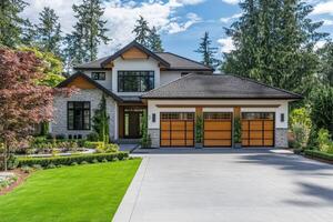 A modern house with a landscaped yard and three-car garage photo