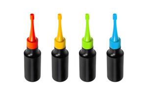 Four black plastic bottles with colorful caps and nozzles, arranged in a row, isolated on a white background photo