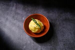 Boiled mashed potatoes are kept in a clay bowl. photo