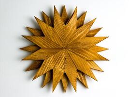 Wooden trivet for hot dishes in the shape of snowflake isolated on white background. Top view. photo
