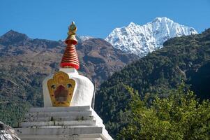 View of Tibetan Buddhist stupa with Mt.Thamserku 6,723m in the background. Thamserku is a prominent mountain to the east of Namche Bazaar, Nepal. photo