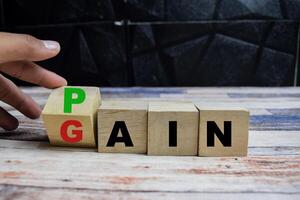 Concept word Pain or Gain, mindset for career growth business on wooden blocks on a wooden table photo