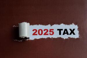The 2025 Tax Text written in torn paper photo