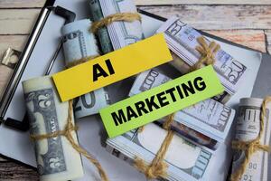 Concept of Ai Marketing write on sticky notes with dollars isolated on Wooden Table. photo