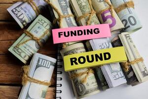 Concept Funding Round on sticky notes on a wooden table with dollar bills photo