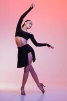 beautiful dance , Confident female dancer in a black outfit performing a dynamic pose with a graceful expression under vibrant studio lighting.. Dance concept, lessons, school photo