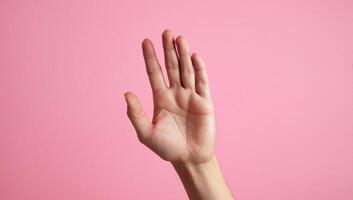Open Hand Gesture Against Pink Background photo