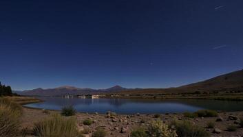 Serene Night Sky Over Tranquil Mountain Lake photo