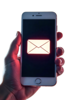 A hand holding a smartphone with a glowing email icon on the screen, isolated on a transparent background png