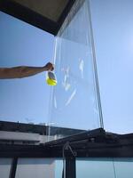 Window cleaner cleaning glass balcony with detergent and sponge in spring time photo