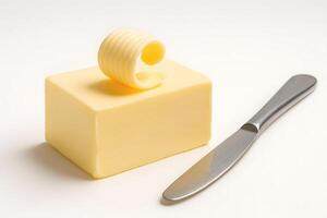 Block of butter with decorative curl and butter knife on white background, dairy product for cooking, baking, and spreading photo