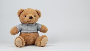 Adorable teddy bear in a cozy sweater on a light background photo