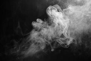 Flowing white smoke dances in the darkness, enveloping the space with an enchanting allure while revealing intricate patterns and shapes photo