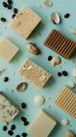 Various natural soap bars are arranged artistically with decorative ingredients on a blue surface photo
