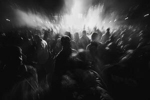 A large gathering of people in black and white fills the area, creating a lively atmosphere during a nighttime event photo