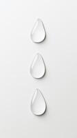 Three water droplets rest on a pristine white surface, reflecting light and emphasizing their clarity. The arrangement conveys a sense of tranquility photo