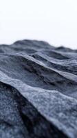 In a dramatic landscape, a black mountain range emerges with textured rock formations under dark blue lighting, creating a striking visual depth and intrigue photo