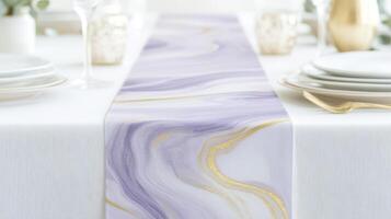 Set on a white table, the elegant pastel purple and gold marble table runner adds a touch of sophistication to a beautifully arranged dining space photo