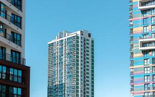 Building with modern architecture. Tall condominium with window facade and multi story design in photo