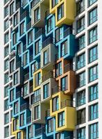 Building with colorful architecture. Tall highrise apartment with multicolored balcony pattern, photo