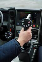 Control stick maneuvering by a pilot on a vessel during overcast weather while navigating through water photo