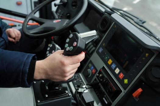 Close-up view of a driver operating heavy machinery with precision controls while on duty in an urban setting during daylight hours photo