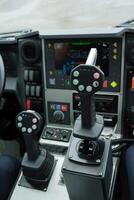 Control panel with joystick handles for operating heavy machinery in a construction site during daylight photo