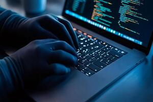 Hacker coding on laptop keyboard wearing gloves, cyber security concept photo