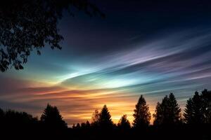 Polar stratospheric clouds shining over the forest at sunset photo