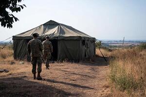Two soldiers walking towards a tent in the field photo