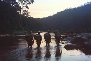 Three soldiers walking across a river at sunset photo