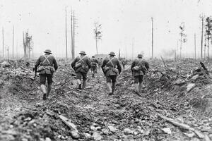 A group of soldiers walking through a field photo