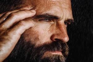 A man with a beard and beard is looking at his face photo
