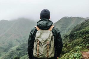 A man with a backpack standing on a mountain photo